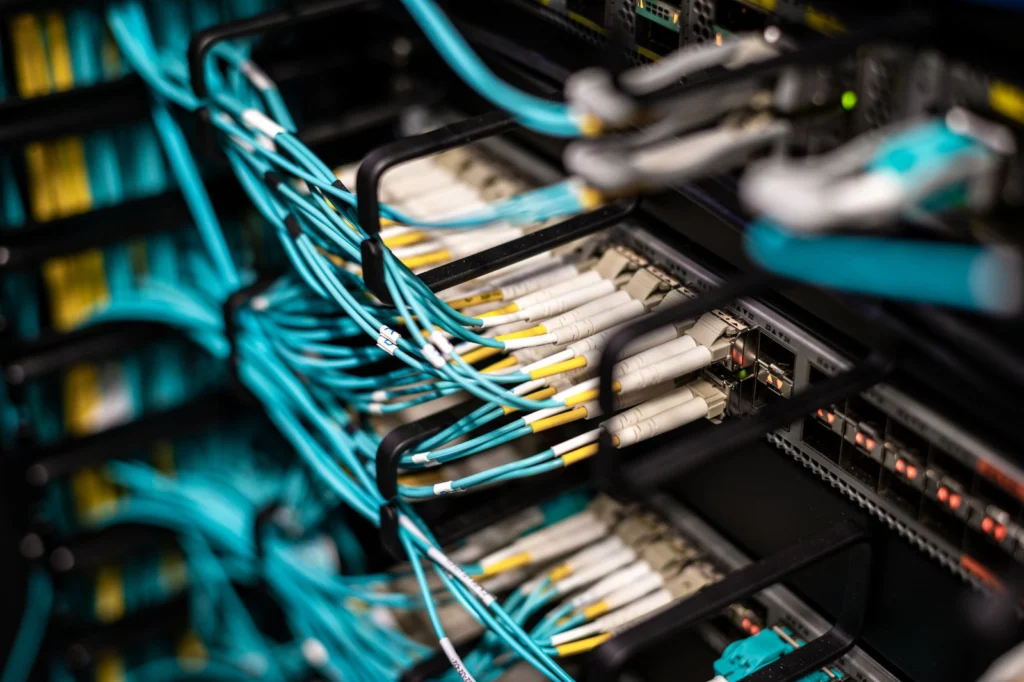Patch cords de fibra óptica conectados a switches con módulos e indicadores encendidos