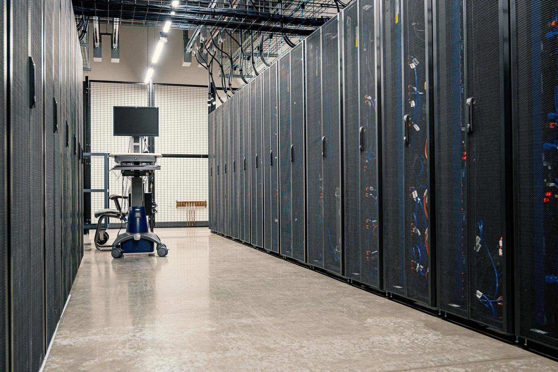 Pasillo de un centro de datos con racks de servidores y cableado de red