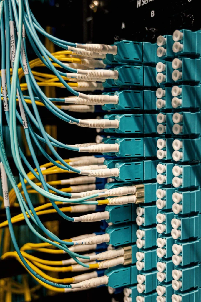 Cables de fibra optica azules y amarillos conectados a un switch en un edificio