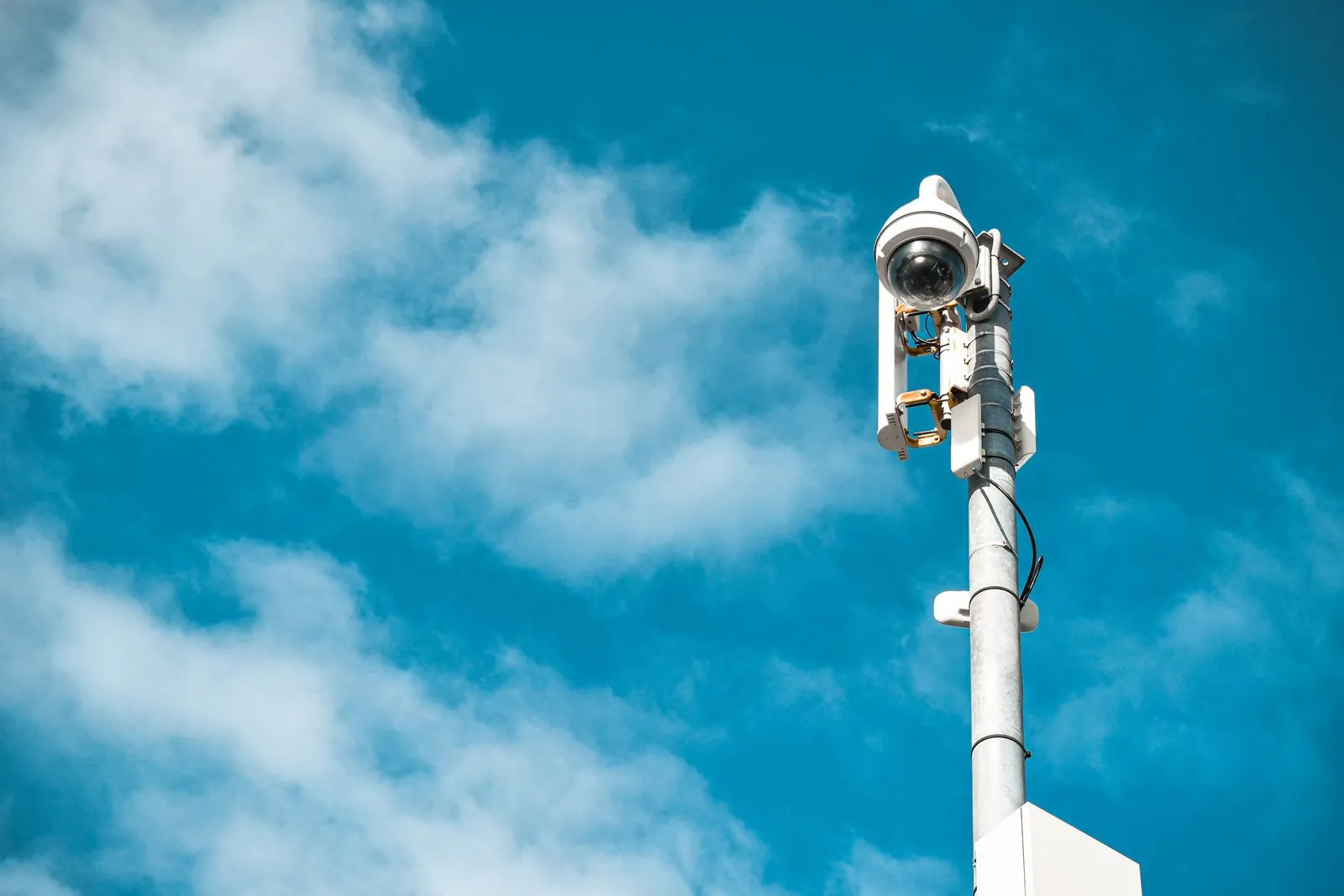 Cámara de videovigilancia montada en un poste, vista contra el cielo