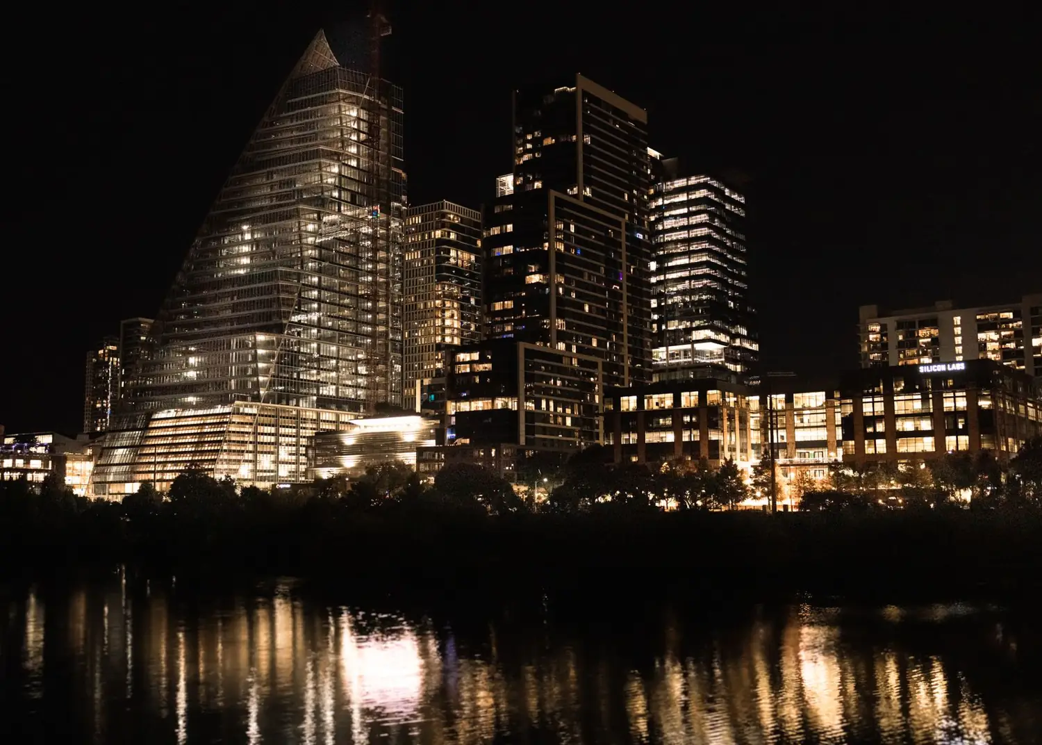Edificios de una ciudad iluminados de noche junto al río