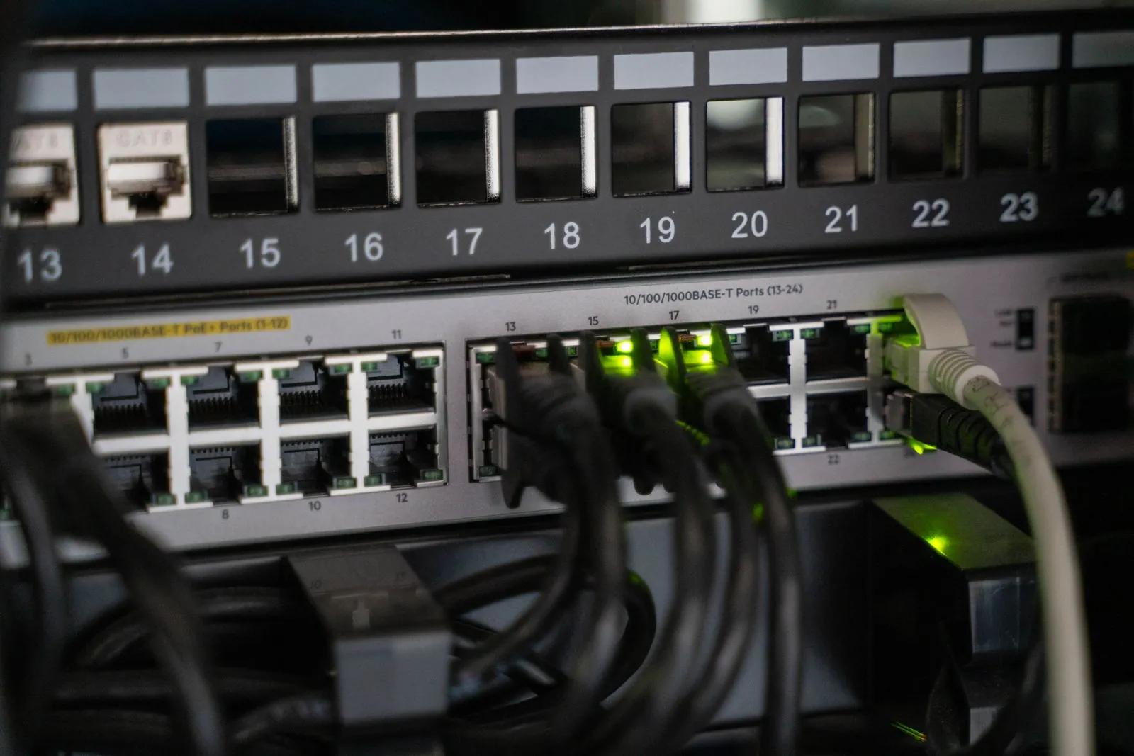 Patch panel numerado instalado arriba de un switch de red en un rack de comunicaciones