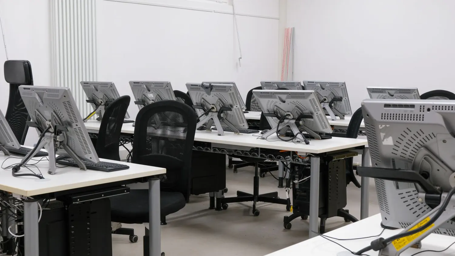 Sala con varias estaciones de trabajo y monitores conectados en red